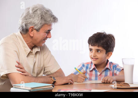 Grandfather helping grandson in homework Stock Photo