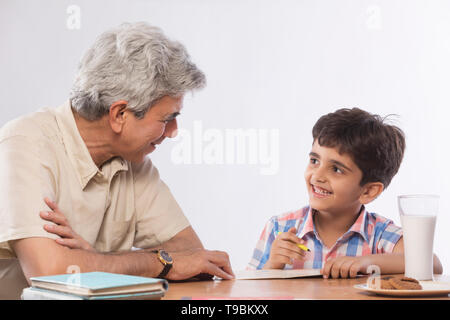 Grandfather helping grandson in homework Stock Photo