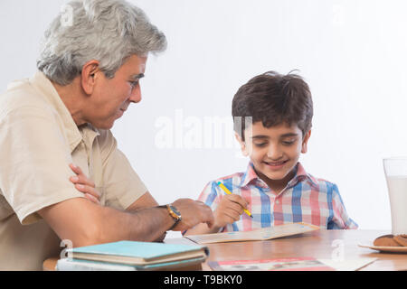 Grandfather helping grandson in homework Stock Photo