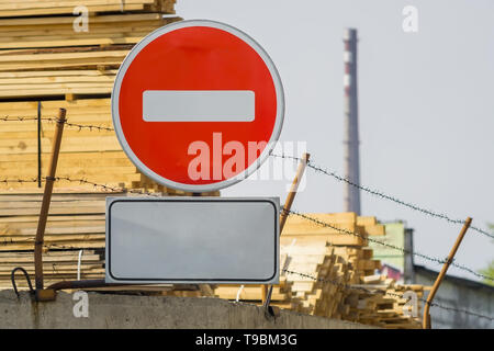 sign, symbol, warning about the prohibition of entry to the territory of the industrial zone with building materials, lumber, placed on the fence Stock Photo