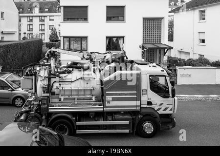 Paris, France - Apr 24, 2019: New Sewage truck on city street in working process to clean up sewerage overflows, cleaning pipelines and potential pollution issues black and white image Stock Photo
