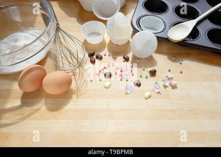 baking cupcakes, tools and ingredients on a wooden kitchen board, copy space, selected focus Stock Photo