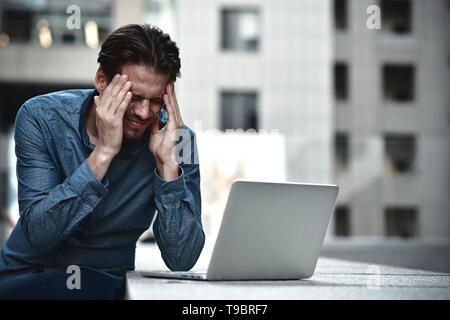 Stressed businessman after project failure. Confused young man frustrated by online problem. Stock Photo