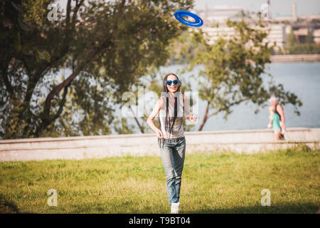 Family playing frisbee on meadow in park Stock Photo