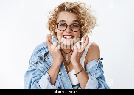 Close-up shot of hopeful enthusiastic and optimistic cute blond girlfriend in glasses, lipctick, denim jacket cross fingers for good luck smiling Stock Photo