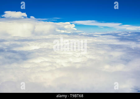 View of the sky clouds above the clouds from airplane window Stock Photo