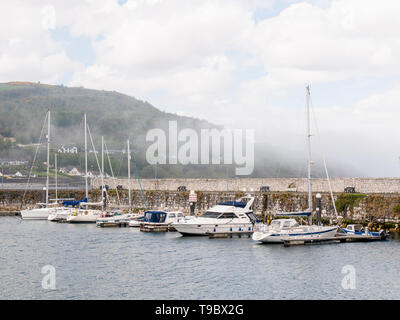 An afternoon mist shrouds yachts in Glenarm Marina. The village sits at the foot of Glenarm Glen, the first of the Nine Glens of Antrim Stock Photo