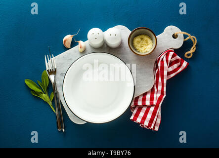 empty served plate on marble serving board and blue spice background Stock Photo