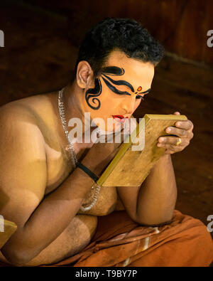 Vertical view of a Kathakali performer applying his distinctive make up in Kerala, India. Stock Photo