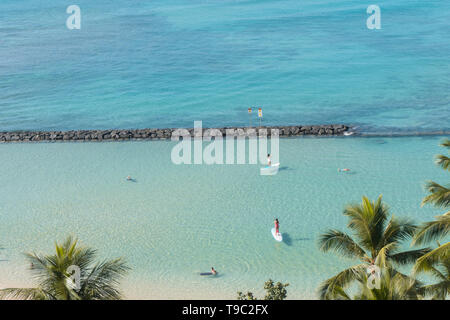 HONOLULU, USA: High angle view of Waikiki Beach in Hawaii. Turquoise sea, palm trees and stand-up paddle. Stock Photo