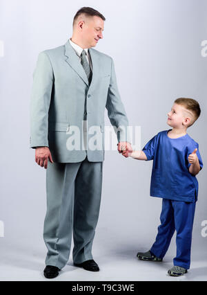 togetherness. trust and values. fathers day. family day. father and son in business suit. male fashion. happy child with father. business partner. small boy doctor with dad businessman. childhood. Stock Photo