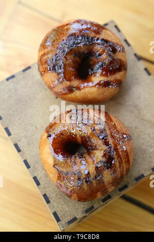 Two chocolate donuts on a wooden background Stock Photo