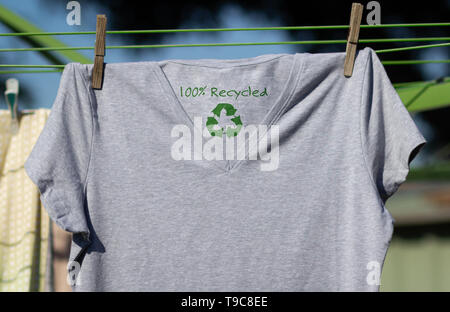 Recycle clothes icon on t shirt with 100% Recycled text, concept illustration reuse, recycle clothes and textiles to reduce waste Stock Photo