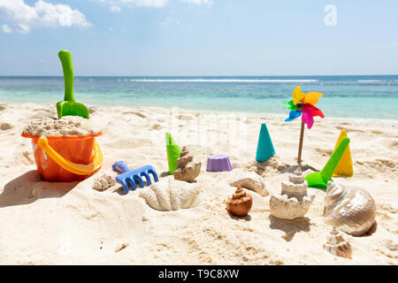 Plastic Toys And Seashells On Sand At Beach Stock Photo