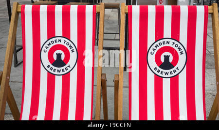 A row of Camden Town Brewery deckchairs outside the Anchor Pub on London's Bankside, London, UK Stock Photo