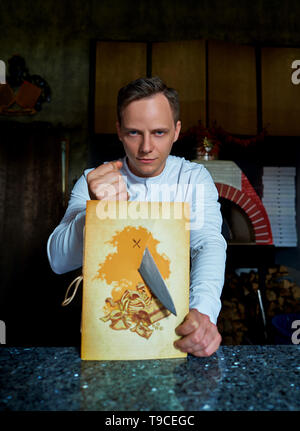 male chef cuts menu with knife Stock Photo
