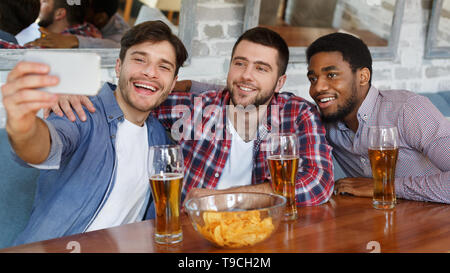 Selfie Time. Diverse Friends Resting At Pub And Drinking Beer Stock Photo