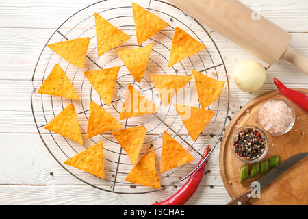 Cooling rack with corn chips and spices on white wooden table Stock Photo
