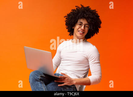 Cheerful african american guy watching webinar on laptop Stock Photo