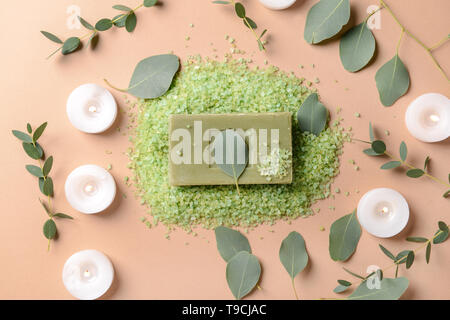 Burning candles with eucalyptus leaves, sea salt and soap bar on color background Stock Photo