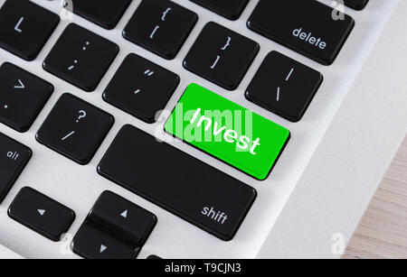Text Invest on green button of computer keypad Stock Photo