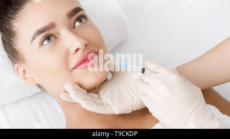 Cosmetologist Making Botox Injection In Female Lips Stock Photo