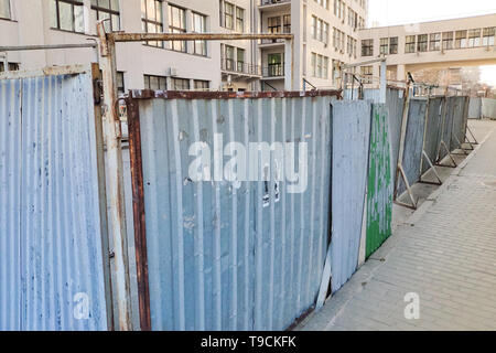 Closeup of fence and scaffolding on a background of a modern office building renovation of a building. Stock Photo