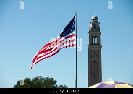 Baton Rouge, Louisiana, USA - 2019: Flag of the United States at the Parade Ground in Louisiana State University, with the Memorial Tower in the back. Stock Photo