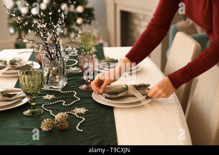Woman setting the table for Christmas dinner Stock Photo