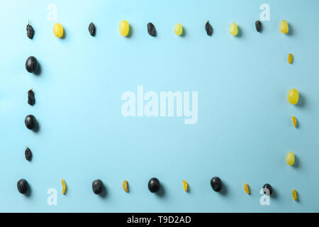Frame made with raisins and grapes on color background Stock Photo