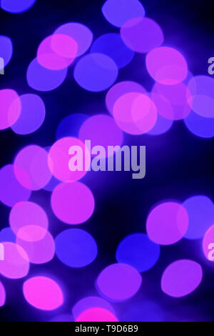 Vertical Image of Abstract Blurred Purple and Pink Illuminated Decorating Light on Dark Background Stock Photo