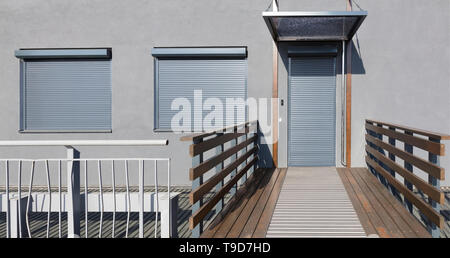 Light gray metal blinds on the doors and windows of the house Stock Photo