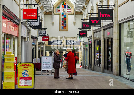 Two older women chatting in a shopping centre in Lancaster, northern Britain Stock Photo