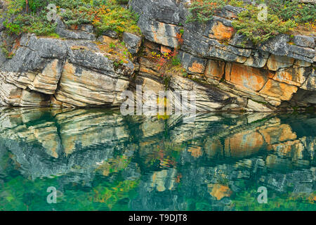 Reflection of shoreline rocks in Horseshoe Lake Jasper National Park Alberta Canada Stock Photo