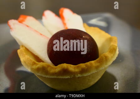 A small fish Petit with a beetroot ball and some pieces of fish sticks Stock Photo