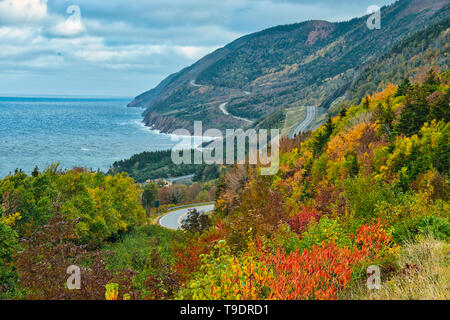 The Cabot Trail along the Gulf of St. Lawrence meanders through the Acadian forest in autumn foliage Cape Breton Highlands National Park Nova Scotia Canada Stock Photo