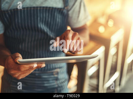 Cafe owner using digital tablet Stock Photo