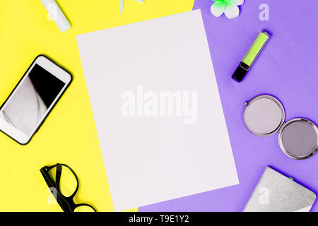 White A4 blank frame on a colorful yellow and purple background with smartphone, mirror, lipstick, glasses, Notepad. sheet of paper for text and adver Stock Photo