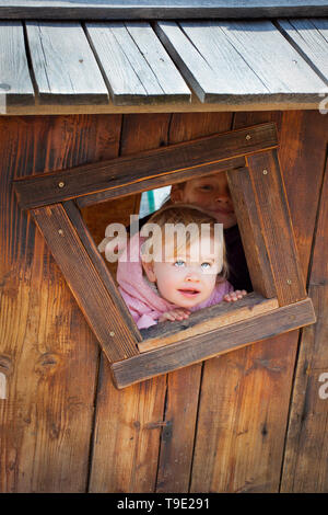 Baby girl looking through window, Kranjska Gora, Slovenia Stock Photo