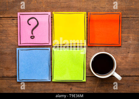 question mark and blank reminder notes - handwriting on colorful sticky notes with a cup of black coffee Stock Photo