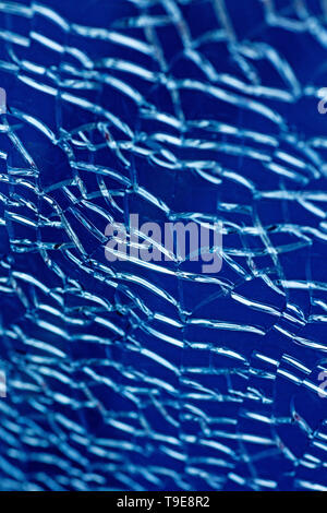 Cracked glass macro blue background high quality prints. Stock Photo