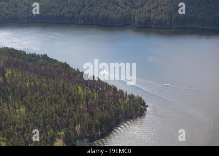 Two boats on the water of Pactola Resivour with pine beetle infested trees on the shore. Stock Photo