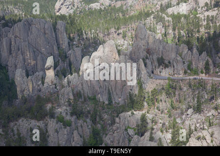 An aerial view of large quartz rock formations with the Needles Eye Tunnel and highway in Custer State Park, South Dakota. Stock Photo