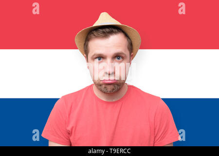 Sad tourist man on dutch flag background Stock Photo