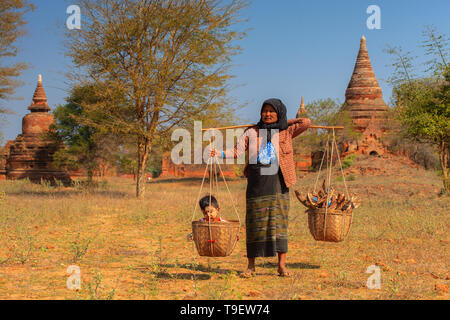 Burmese woman carrying her baby in a basket Stock Photo