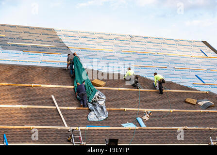 King of Prussia, PA - May 2, 2019: Roofers installing CertainTeed Roofing products on a large roof. CertainTeed Corporation is a North American manufa Stock Photo