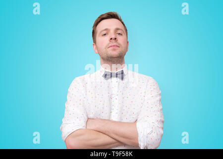 young man in white shirt standing with arms crossed Stock Photo