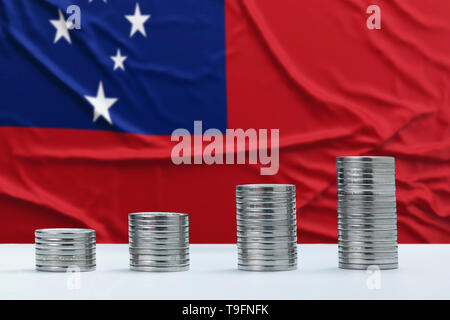 Wrinkled Samoa flag in the background with rows of coins for finance and business concept. Saving money. Stock Photo