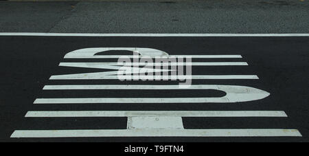 Road warning painted on the ground warning that there is a 'hump ahead' in reference to a speed bump Stock Photo