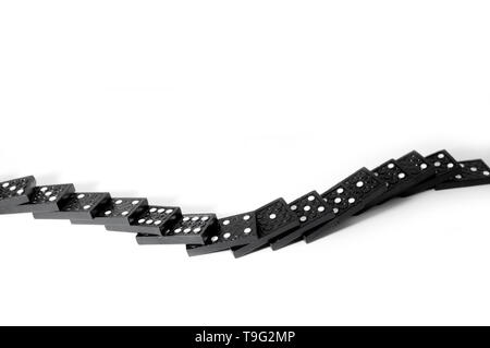 Black dominoes fallen in a row isolated on a white background Stock Photo